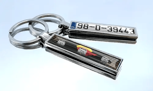 Metal comic keychain with car design and license plate detail