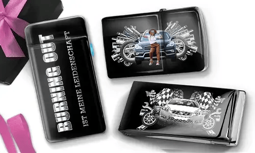 Drei schwarze Geldbörsen mit Auto-Designs. Eine trägt die Aufschrift „Burning Out ist meine Leidenschaft“, eine andere zeigt ein Auto mit Kolben und einer Person, und die dritte zeigt ein Auto mit karierten Flaggen und Kolben. In der Ecke liegt eine violette Schleife.