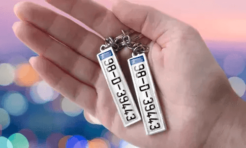 Llaveros con placa personalizada y números personalizados, sostenidos en la mano