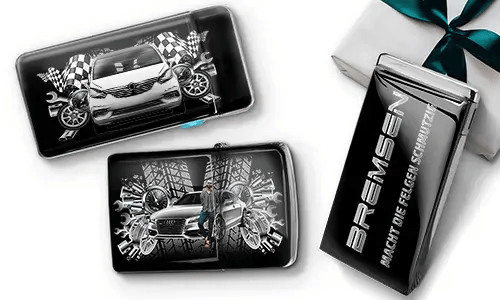 Car-themed wallets featuring sleek cars, checkered flags, and tire patterns on a black background. Beside them, a black gift box with silver text.