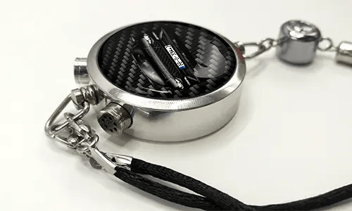 Round car key fob with carbon fiber face, buttons labeled LOCK and UNLOCK, braided black cord attached