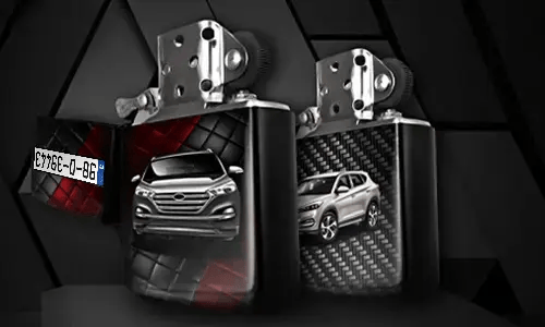 Two metallic lighters with silver SUV designs: one front view on tread background, one side view with carbon texture, small rectangular object in corner
