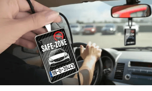 Auto-Safezone-Anhänger mit Carbon Hintergrund in der Hand Auto-Schutzraum-Anhänger